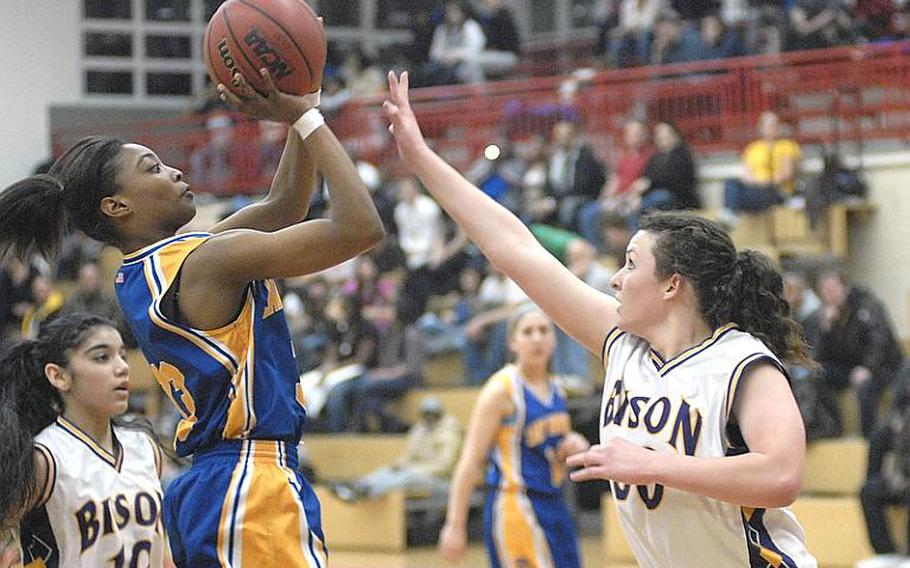 Wiesbaden senior Kelley Colbert, left, shoots over Mannheim sophomore Emma Roberts in Wiesbaden&#39;s win over Mannheim on Friday night. Wiesbaden, the defending Division I champion, will take its unblemished record into the DODDS-Europe basketball championships in Mannheim, Germany this week, while the Lady Bison are 6-9 going into the Division II tournament.