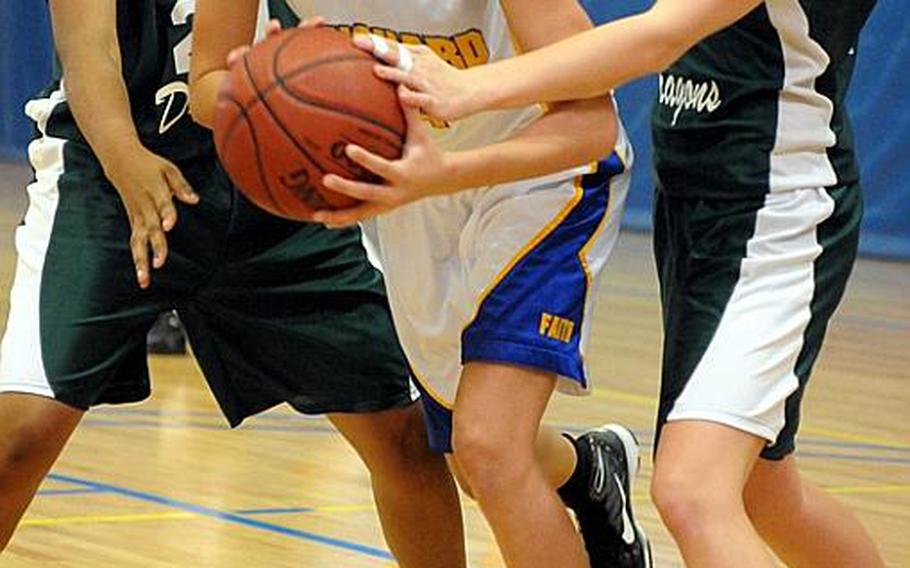 Faith Academy's Kelly Hardeman fights her way out from between Kubasaki defenders Shakayla McGuire and D'An Hurst during Wednesday's single-elimination playoff game in the Far East High School Girls Division I Basketball Tournament at Charles King Fitness & Sports Center, Naval Base Guam. Faith won, 44-18.