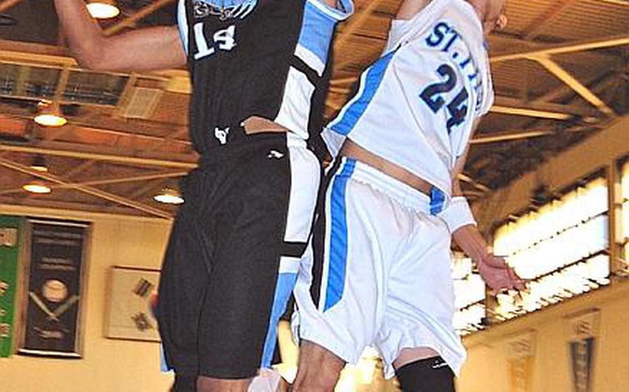 Jeff Tinsley of Osan American and St. Paul Christian's Kory Borja sky for the rebound during Thursday's double-elimination playoff game in the Far East High School Boys Division II Basketball Tournament at  Daegu American School, South Korea. St. Paul won, 54-45.