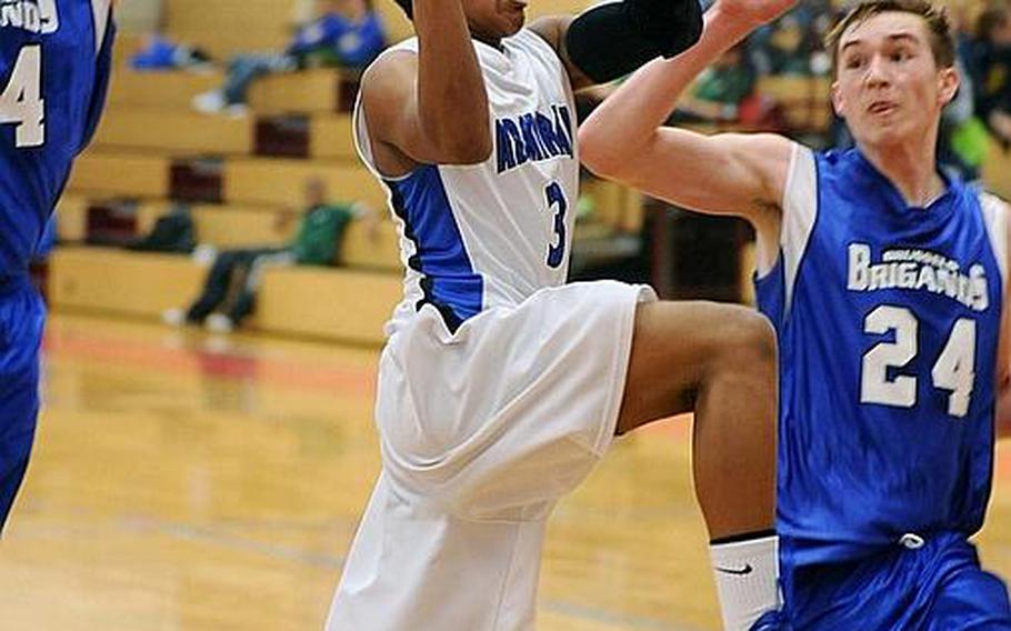 Rota's Terrence Paris drives to the basket against Ivan Cular, left, and Braden Brower of Brussels in a Division III game in Mannheim, on Thursday. Rota won the game, 53-18.