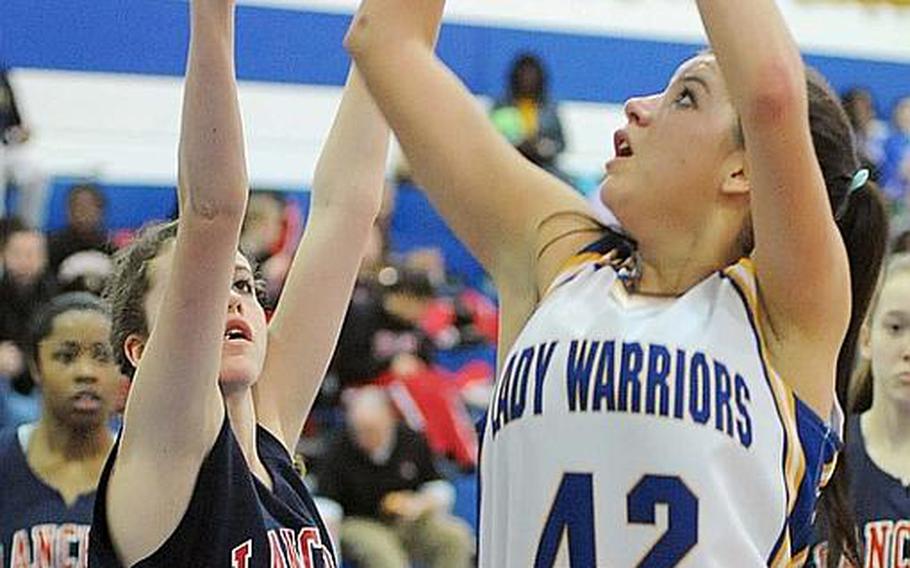 Wiesbadens Taylor Dore shoots over Lakenheath's Alexis Castellanos in their Division I game at the DODD Europe basketball finals on Thursday. The defending champion Lady Warriors beat Lakenheath, 34-20.