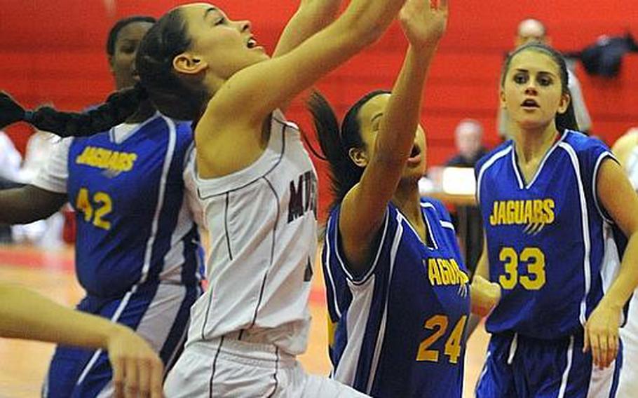 Menwith Hill's Rachael Solini, left, gets a shot off despite the defense of Sigonella's Deeanna Brown in a Division III game at the DODDS Europe basketball finals in Mannheim. Menwith Hill, the top seed, defeated Sigonella 27-22.