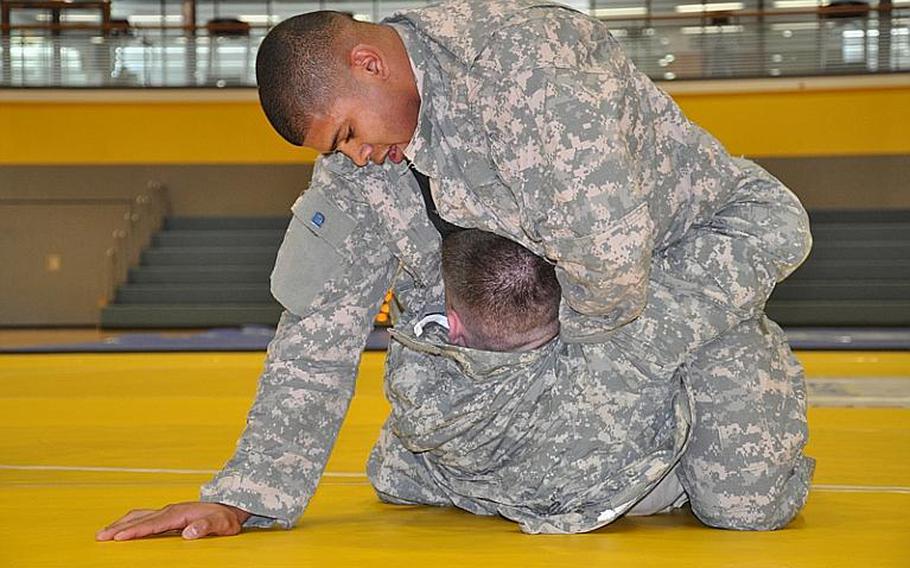 Benjamin Cardoza, top, battles David Shelley at the second annual European Forces Combatives Championships in Bamberg, Germany, on Friday. Cardoza won the championship match in the light heavyweight bracket.