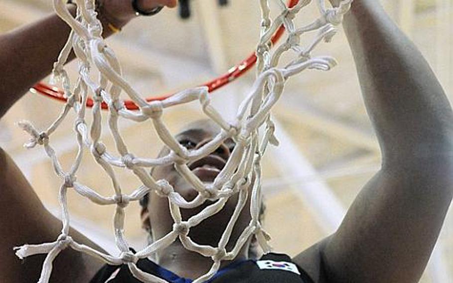 Seoul American senior Jordan Elliott cuts down the net cords after Saturday's championship game in the Far East High School Girls Division I Basketball Tournament at Charles King Fitness & Sports Center, Naval Base, Guam. Seoul American beat Faith Academy for the second straight year, 47-39.