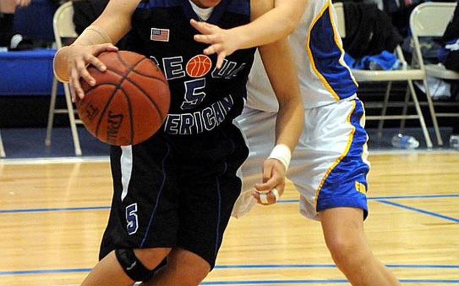 Seoul American senior Liz Gleaves dribbles past Liz Hardeman of Faith Academy during Saturday's championship game in the Far East High School Girls Division I Basketball Tournament at Charles King Fitness & Sports Center, Naval Base, Guam. Seoul American beat Faith Academy for the second straight year, 47-39.