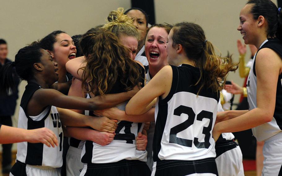The Vicenza Lady Cougars celebrate their 37-36 overtime victory over Black Forest Academy in the Division II championship game at the DODDS Europe basketball tournament in Mannheim, Germany, on Saturday.