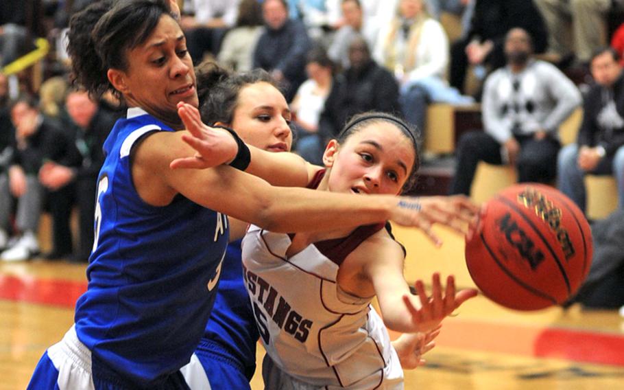 Rota's Bri'anna Am'mons, left, and Menwith Hill's Rachael Solini fight for a ball in the girls Division III championship game at the DODDS Europe basketball tournament on Saturday. Menwith Hill defeated Rota, 38-35, to take the title. At center is Rota's Thais Gartland-Bonet.