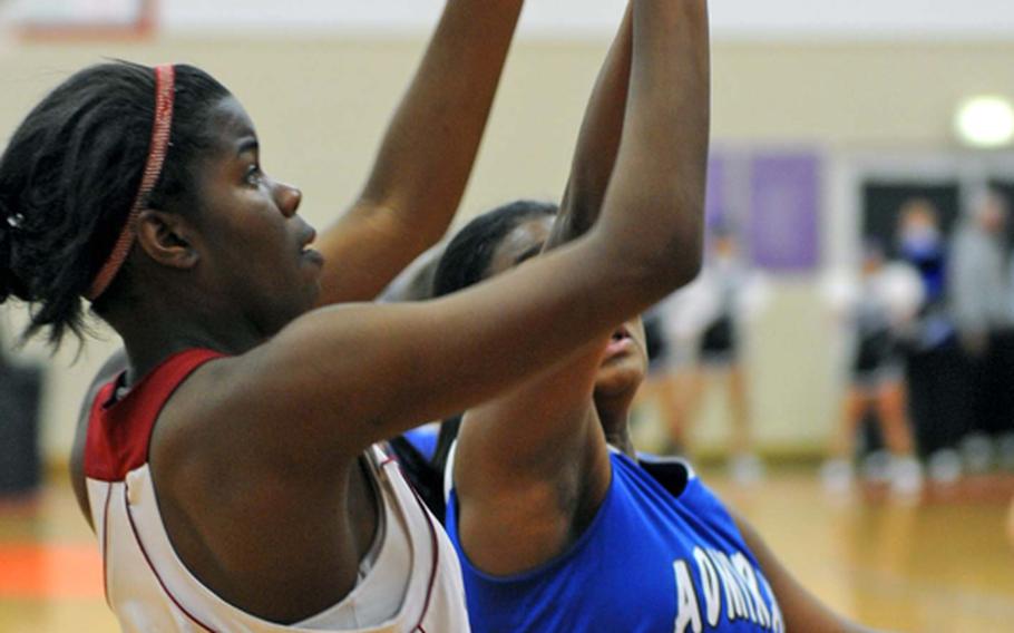 Menwith Hill's Monique McCreary shoots over the defense of Rotas Allana Shelton in the Division III girls final at the DODDS Europe basketball championships in Mannheim, Germany, on Saturday. Menwith Hill took the title with a 38-35 win.