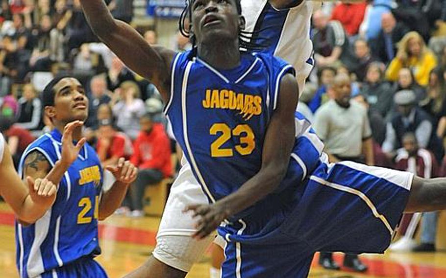 Sigonella's Larry Stevenson uses an acrobatic move to get past Rota's Tre'von Owens in the Division III title game. Rota won the game, 65-61.