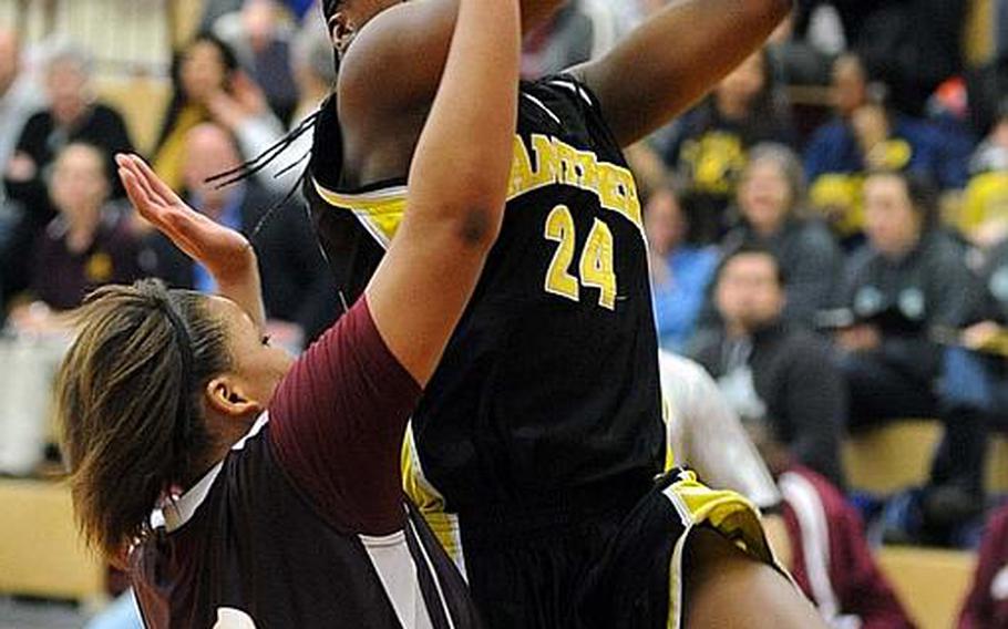Patch's Nelley Loney, right, eyes the basket despite the coverage of Vilseck's Deraj McClinton.  Patch captured the girls Division I title by beating Vilseck, 64-52.