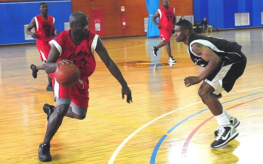 Robert Trisby, playing for Marine Corps Base S.D. Butler, comes up against Antonio Gibson from 3rd Marine Logistics Group during the third night of the Marine Corps Far East Regional Basketball Tournament.  3rd MLG went on to win the game, 67-51.