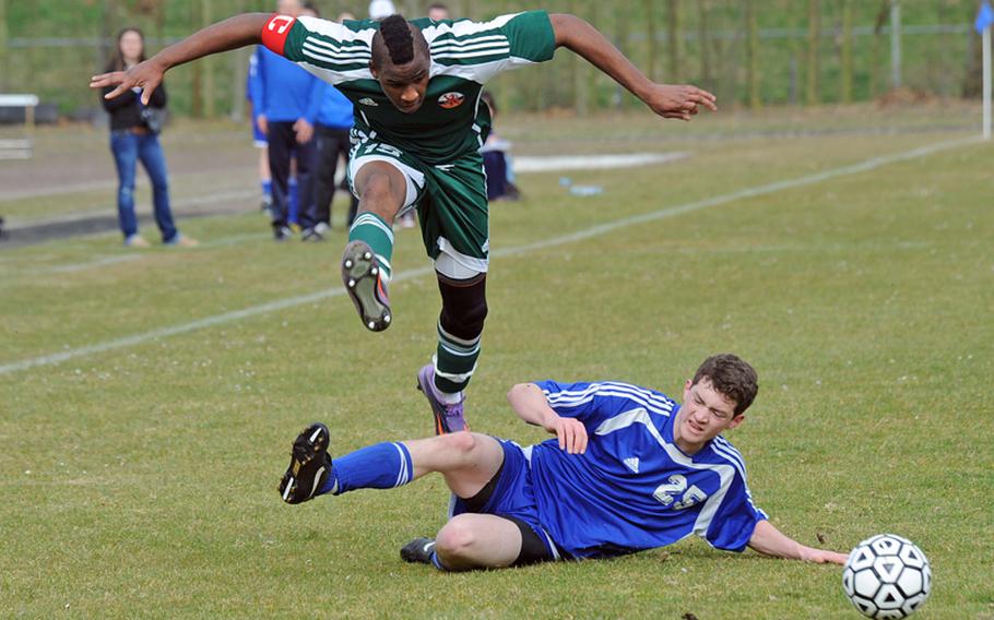AFNORTH's Tony Norman, left, escapes a sliding tackle attempt by Ryan Bottesini of Brussels in a game at AFNORTH on Saturday. Brussels came from behind to win the game, 3-2.