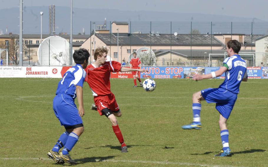 Kaiserslautern sophomore striker Cody Tremaine shoots between Wiesbaden seniors Alexander Hernandez, left, and Jeffrey Holt  at the Stadion In der Witz in Mainz-Kastel, Germany.  Tremaine scored the only goal for the Raiders, who ended the match in a 1-1 draw with Wiesbaden.