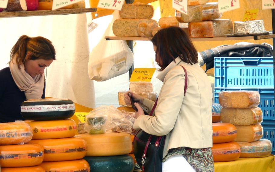 A customer shops for cheese at a stand at the ?s Hertogenbosch, Netherlands, market.