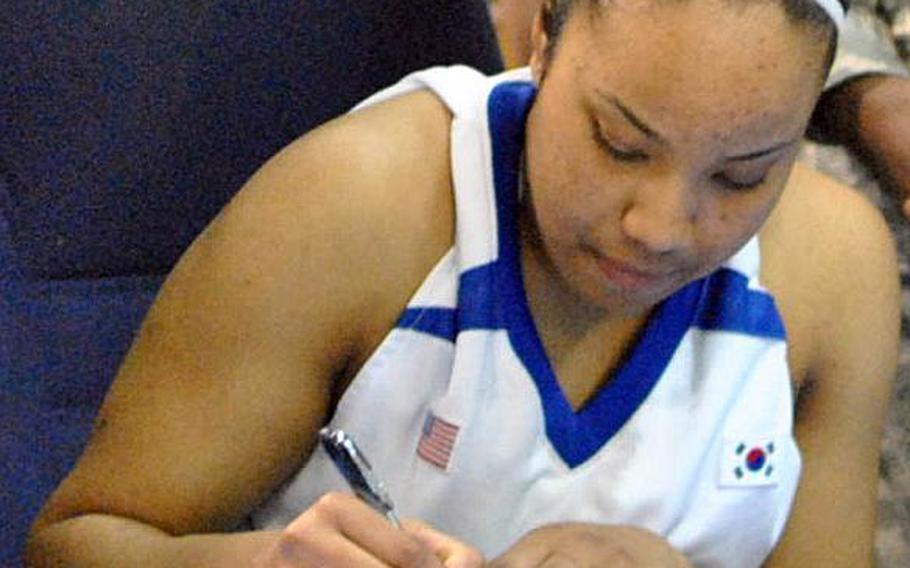 Senior guard Jordan Elliott of the two-time Far East Division I Tournament champion Seoul American Falcons signs a national letter of intent to play basketball for the U.S. Military Academy at West Point, N.Y.