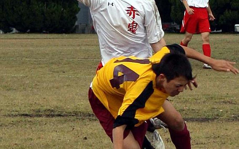 Matthew C. Perry striker Dan Holmes, bottom, and Nile C. Kinnick sweeper Marcus Boehler collide during  Saturday's championship match in a six-team DODDS Japan regular-season tournament at Matthew C. Perry High School,  Japan. Perry blanked Nile C. Kinnick, 1-0, and ran its school-best regular-season record to 14-1-1.