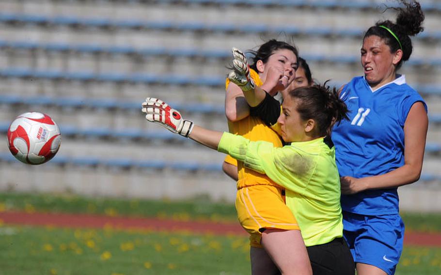 Baumholder goalie Rachel Krahn knocks the ball out of the danger zone in front of teammate Laura Bailes, left, and Ramstein's Makenzie Crews. Krahn's efforts were for naught on Saturday as the Ramstein beat Baumholder, 7-0.