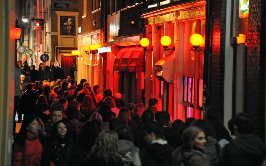 A Greek tour group passes through Amsterdam's red-light district on a recent spring evening. The city's area of sin, with prostitutes standing in red-lit windows, is also an attraction for adult tourists.