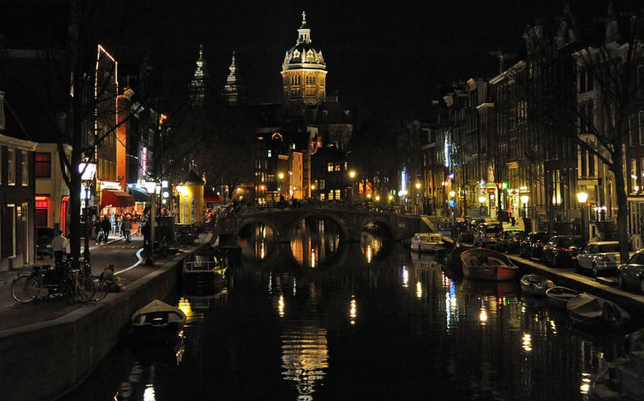 The Sint Nicolaaskerk is reflected in the waters of the Oudezijds Voorburgwal canal in Amsterdam.