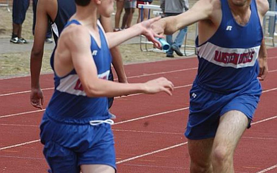 Ramstein's Mark Davis hands the baton to Jack Scranton during the 4x800-meter relay at RAF Lakenheath, England. The Royals breezed to victory by nearly 30 seconds over runner-up Alconbury.