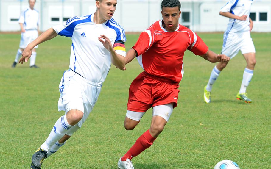Ramstein's Jonathon McLouth, left, tries to get by Kaiserslautern defender Dominique Williams during Ramstein's 4-0 win over the Raiders last week. Ramstein is the top seed in Division I going in to this week's DODDS-Europe soccer championships, while the Raiders are seeded seventh.