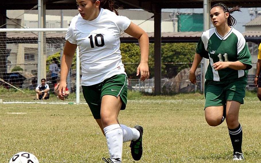 Daegu American's Sarah Wright (10) pulls ahead of Robert D. Edgren's Jackie Horton (11) during Tuesday's pool-play match in the 2011 Far East High School Girls Division II Soccer Tournament at Penny Lake Field, Marine Corps Air Station Iwakuni, Japan. Daegu blanked Edgren 7-0 in a match that was called off with 1 minute, 40 seconds left due to a thunderstorm.