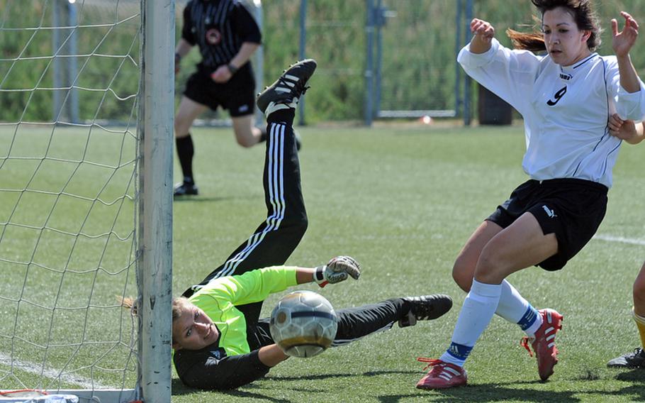 SHAPE keeper Meghan Fleet knocks the ball around the post before Patch's Elysia Verones can get a shot on goal. Verones had a goal and an assist in Patch's 2-0 win in a Division I game on opening day of the 2011 DODDS-Europe soccer championships.