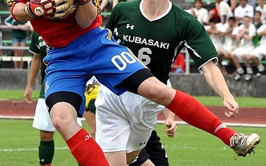 Seoul American goalkeeper Kenneth Butts covers up the ball in front of Kubasaki's Jon Goddard during Friday's championship match in the 2011 Far East High School Boys Division I Soccer Tournament at Camp Foster, Okinawa. Butts was named the tournament's Best Goalkeeper and the Falcons prevailed over the host Dragons, 1-0, in double-overtime.