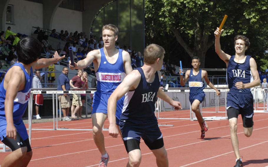 Black Forest Academy sophomore Ben Kronk prepares to pass the baton  to senior teammate David Grano during the boys 4x800 meter relay at the DODDS-Europe Track and Field Championships in Russelsheim, Germany. BFA trailed Ramstein at the time, as senior Spencer Gillespie hands the baton off to junior Young Oh, but finished fast, winning the race in a DODDS-Europe record time of 8 minutes, 9.56 seconds.