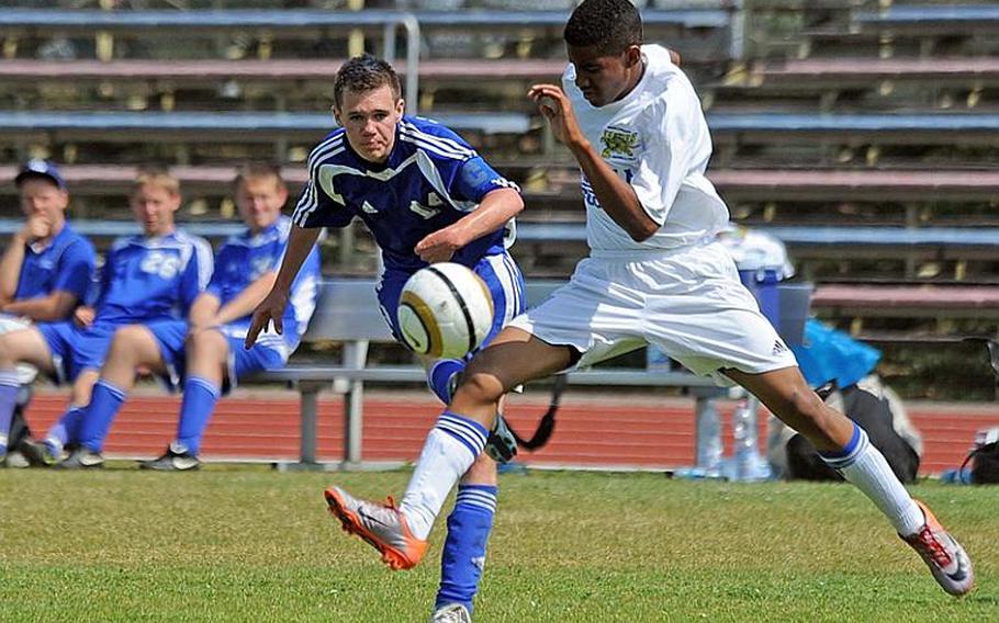 Jamie Hunt of Brussels, left, gets a shot on goal against Sigonella's Marco Montero in the DODDS-Europe  Division III soccer title game on Saturday. Sigonella won, 2-0.