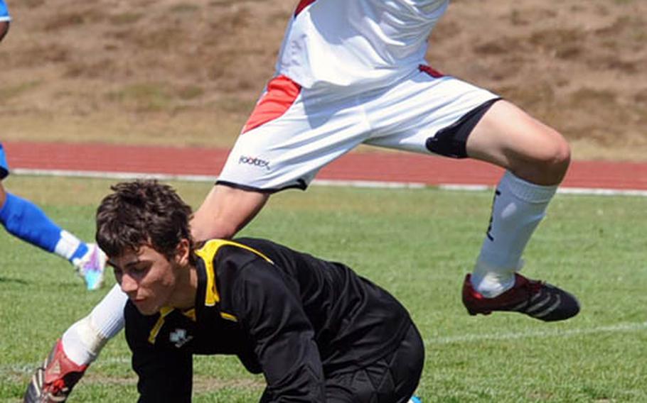 Marymount International keeper Riccardo Cerza covers the ball from a charging Trevor Lapage of AOSR in the boys DODDS-Europe Division II boys soccer championship game in Ramstein on Saturday. Hannan and his teammates shut out their crosstown rivals, 2-0, to take the crown.