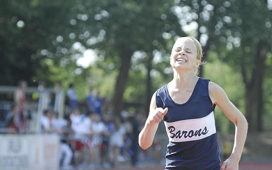 Bitburg junior Kaitlyn Miller grimaces during the final lap of the girls 3,000 meter run at on the second day of  the 2011 DODDS-Europe Track and Field Championships in Russelsheim, Germany. Miller won the  event with a time of 10 minutes, 46.08 seconds.