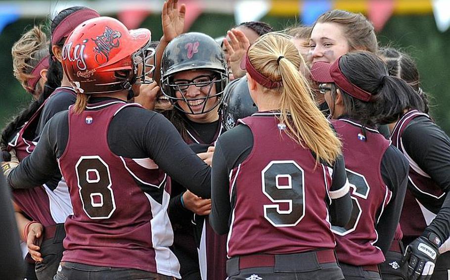 Alex Lopex, center, is congratulated by her teammates after she knocked in the winning run with a walk-off hit in the Falcons' 11-10 win over Wiesbaden on the first day of action at the DODDS-Europe Division I softball championships.