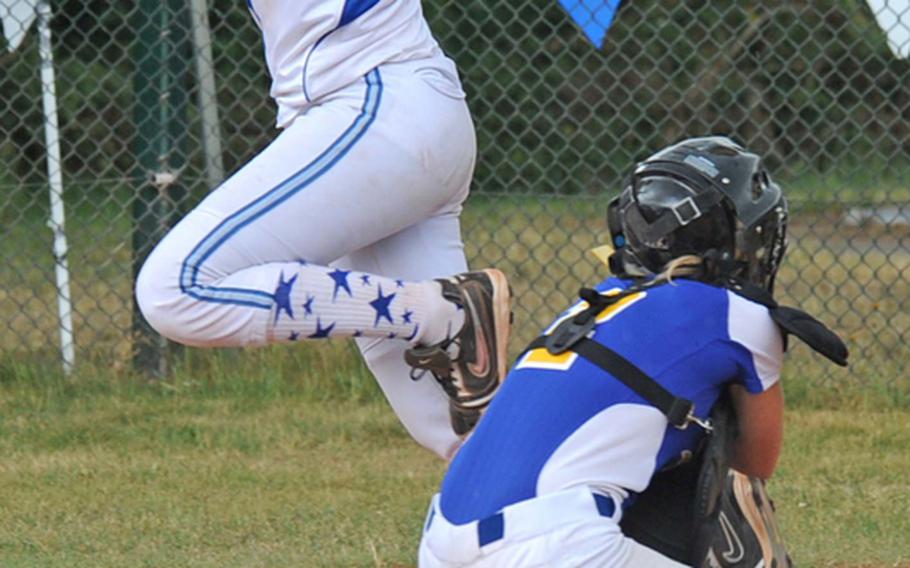 After stepping on the plate, Rota's Natalia Rivera leaps over Sigonella catcher Bailey Berryhill. Sigonella won the Division III semifinal 10-8 to advance to Saturday's division title game against Incirlik.