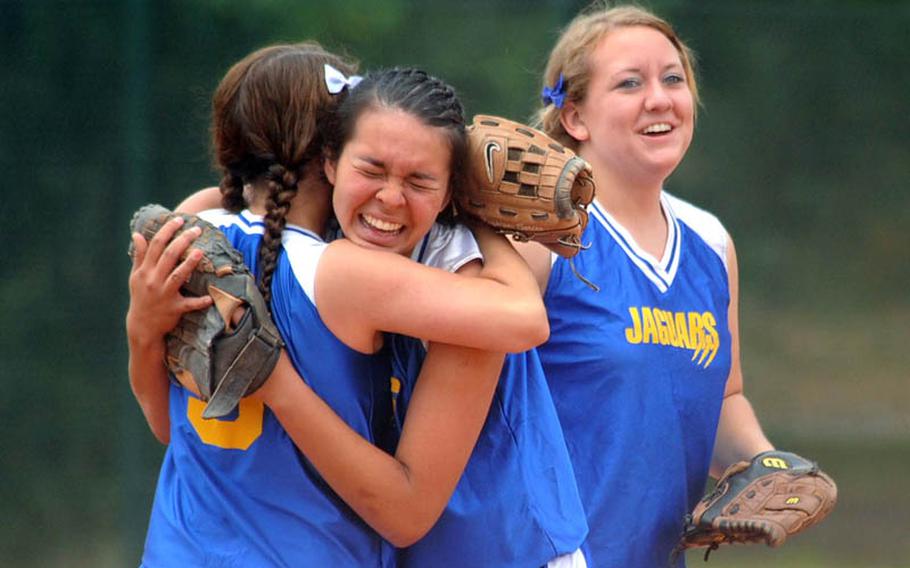 Sigonella relief pitcher Courtney Albert, left, hugs Alexis Palmer after she snagged a line drive and threw the runner out at first for a final-inning double play as the Jaguars beat Incirlik 13-11 to capture the Division III softball title. At right is starting pitcher Elizabeth Adams, who was playing at shortstop.