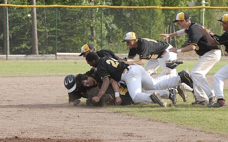Patch players pounce on senior Cavan Cohoes after his game-winning hit as the Panthers retained their Division I baseball title with an 8-7 win over Ramstein.