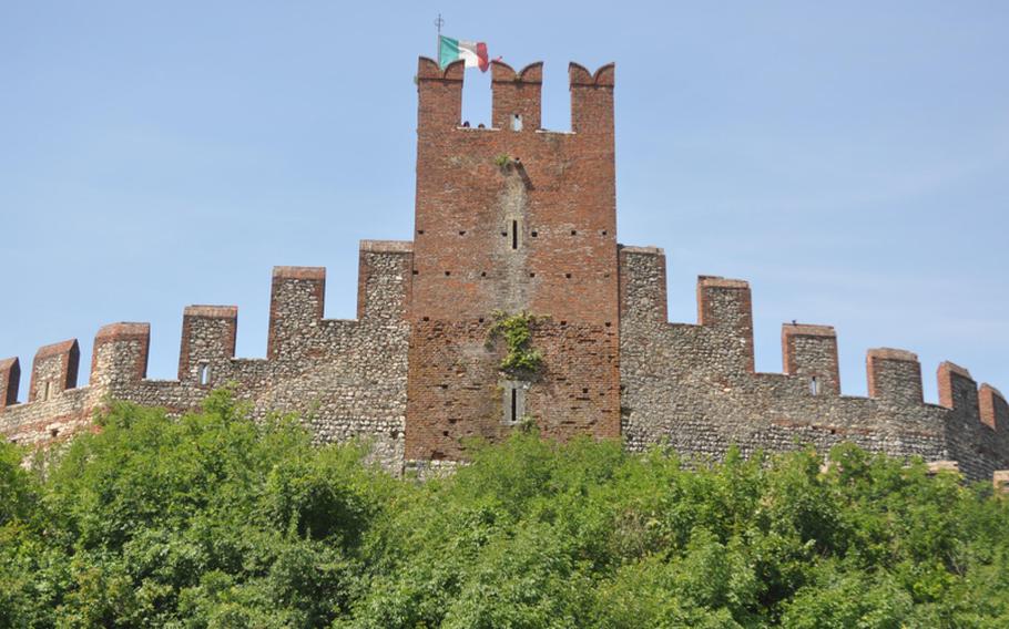 The Italian flag waves from the highest tower in the walled city  of Soave, Italy. The fortress dates to the Middle Ages and was likely built on top of a structure from the Roman Empire. Today, the city is known for the walls and the wine produced  from the many vineyards surrounding them.
