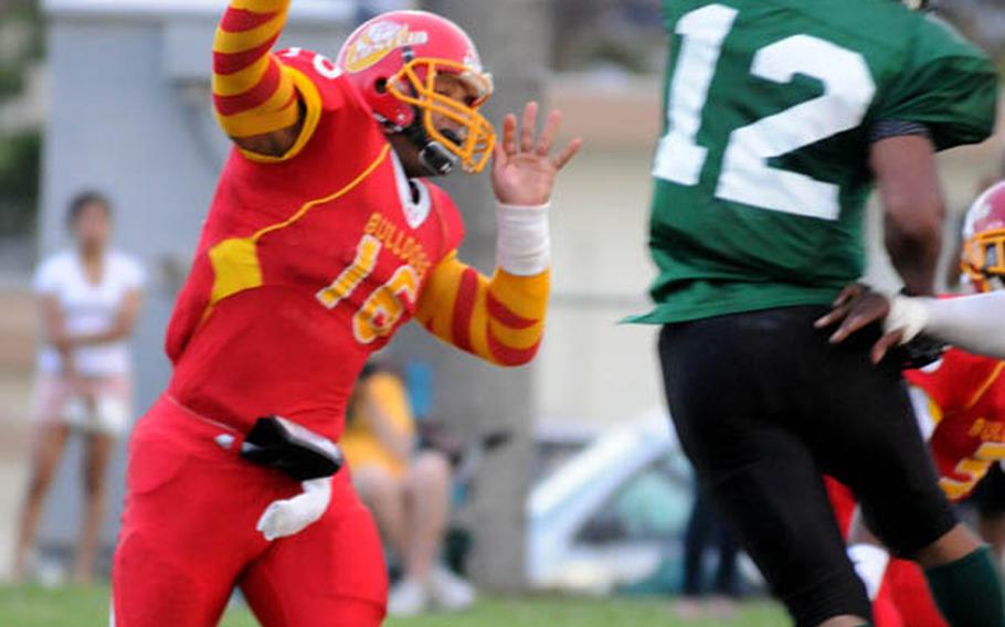 Foster Bulldogs quarterback James Sanford tosses the pigskin as Joint Task Force Wolfpack linebacker Anthony Banks leaps to block it during Saturday's U.S. Forces Japan-American Football League South Division season-opening game.