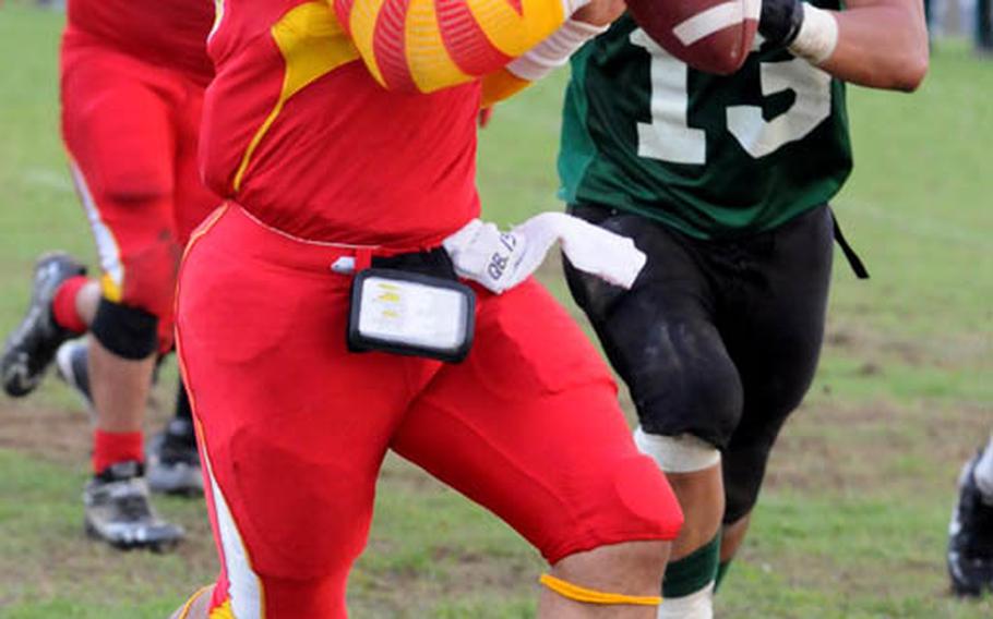 Foster Bulldogs quarterback James Sanford gets chased by Joint Task Force Wolfpack linebacker Joshua Lacy during Saturday's U.S. Forces Japan-American Football League South Division season-opening game.