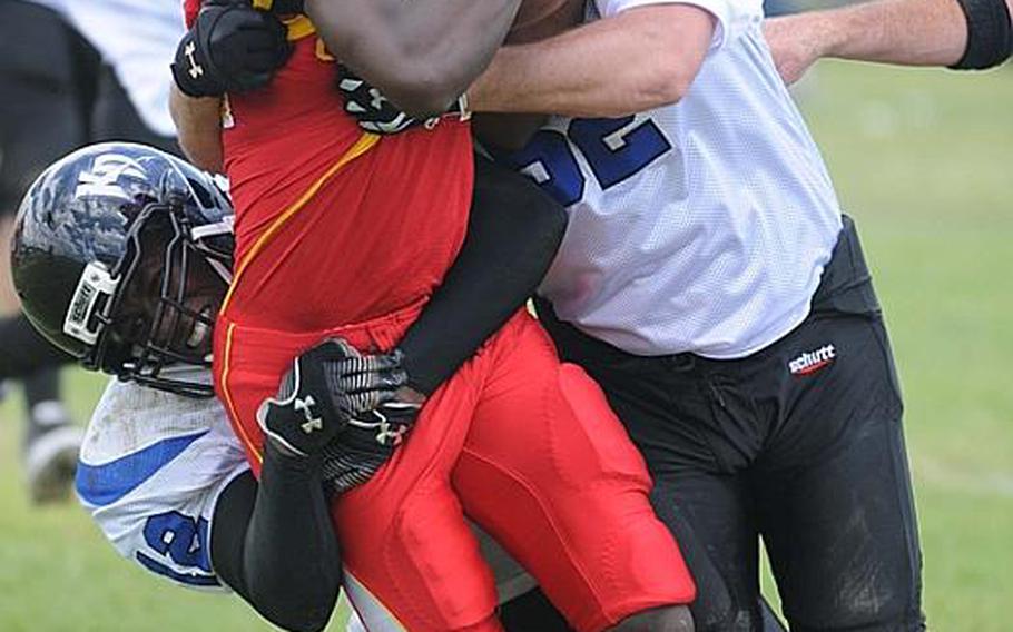 Kadena Dragons defenders Terrence Nash, left, and Brian Walser sandwich Foster Bulldogs receiver Ricky Shorter during Saturday's U.S. Forces Japan-American Football League South Division game at Camp Foster, Okinawa. Foster won 30-14 and took a 11/2-game lead in the division over Kadena and Joint Task Force, each 0-1.