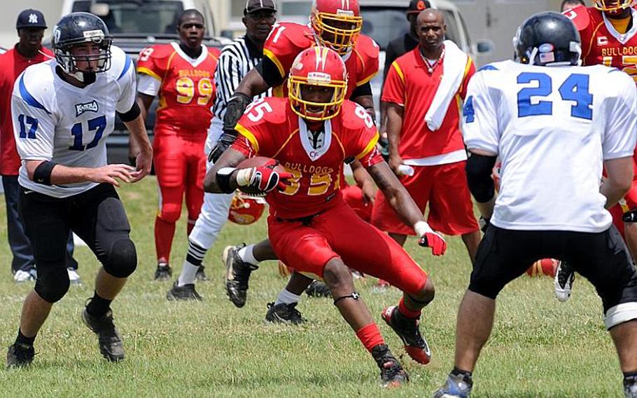 Foster Bulldogs receiver Roger Veal looks for running room between Kadena Dragons defenders Nicholas Warden, left and Randy Lambert during Saturday's U.S. Forces Japan-American Football League South Division game at Camp Foster, Okinawa. Foster won 30-14 and took a 11/2-game lead in the division over Kadena and Joint Task Force, each 0-1.