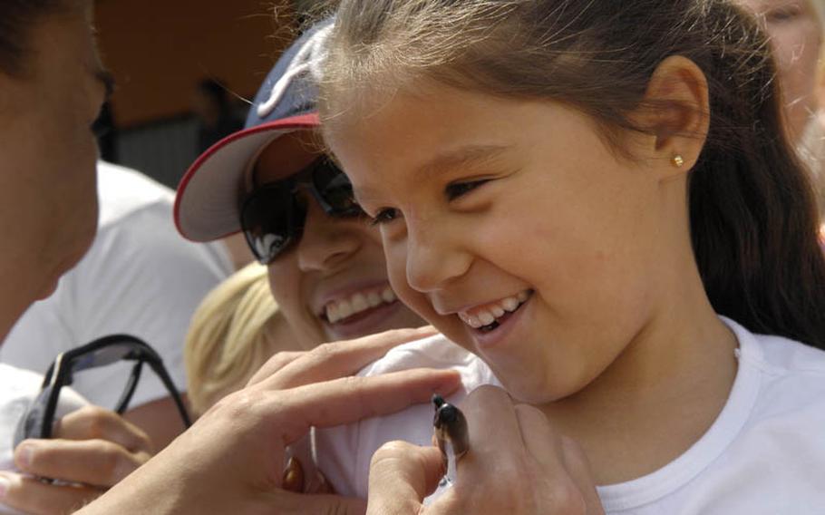 Six-year-old Camila Ramirez gets her T-shirt autographed by Hope Solo, the U.S. Women's National Team goalkeeper after Thursday's soccer practice at SG Kirchheim soccer field in Heidelberg, Germany. Camila's father is a U.S. Army warrant officer stationed in Stuttgart, Germany.