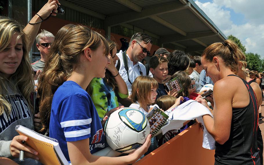Christie Rampone, right, and other members of the U.S. women's national soccer team sign autographs Thursday following an open practice session in Heidelberg, Germany. The practice was attended by hundreds of members of the American military communities. The women play their second game of the World Cup against Colombia on Saturday in Sinsheim.