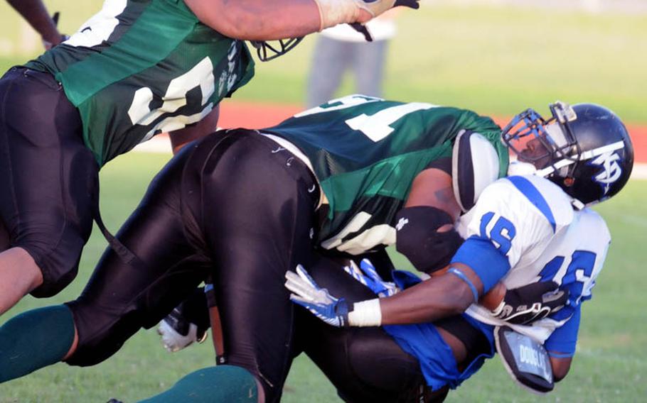 Joint Task Force Wolf Pack defenders Angel Skinner and Kentrell McCoy flatten Kadena Dragons quarterback Kelvin Lewis during Saturday's U.S. Forces Japan-American Football League South Division game at Camp Foster, Okinawa. Kadena won 22-12 and leveled its record at 2-2, earning host rights to the July 30 first-round playoff game against JTF (0-3).