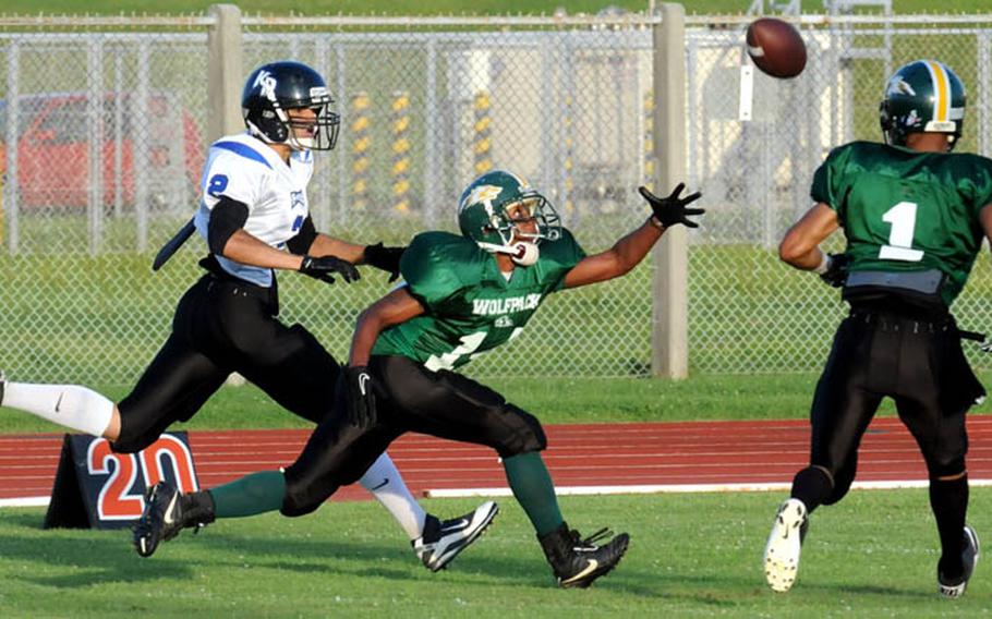 A pass intended for Kadena Dragons receiver Eric Lorenzo falls just out of reach of Joint Task Force Wolf Pack defenders John Butler and Jonathan Gibbs during Saturday's U.S. Forces Japan-American Football League South Division game at Camp Foster, Okinawa. Kadena won 22-12 and leveled its record at 2-2, earning host rights to the July 30 first-round playoff game against JTF (0-3).