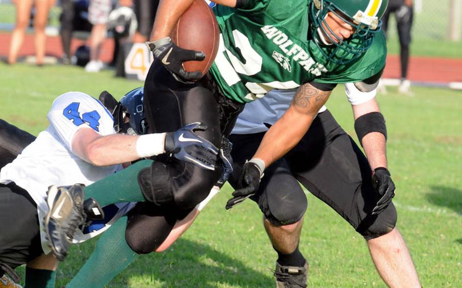 Joint Task Force Wolf Pack running back Enrique Menendez drags Kadena Dragons defender Randall Machuka with him during Saturday's U.S. Forces Japan-American Football League South Division game at Camp Foster, Okinawa. Kadena won 22-12 and leveled its record at 2-2, earning host rights to the July 30 first-round playoff game against JTF (0-3).