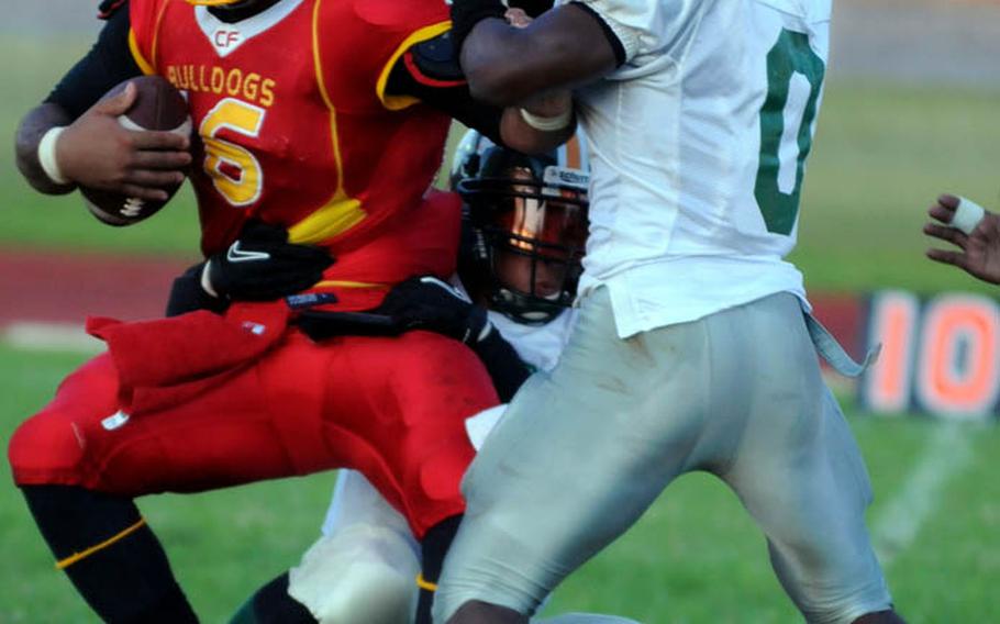 Foster Bulldogs quarterback James Sanford battles to free himself from two Joint Task Force Wolfpack defenders, including Kent Onuoha, right, during Saturday's U.S. Forces Japan-American Football League South Division season finale at Camp Foster, Okinawa. Foster won 30-8 to complete a 4-0 regular season.