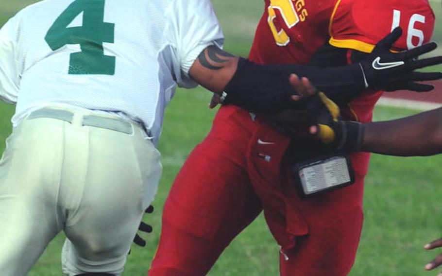 Foster Bulldogs quarterback James Sanford  tries to elude the grasp of Joint Task Force Wolfpack defender Jorge delosRios during Saturday's U.S. Forces Japan-American Football League South Division season finale at Camp Foster, Okinawa. Foster won 30-8 to complete a 4-0 regular season.