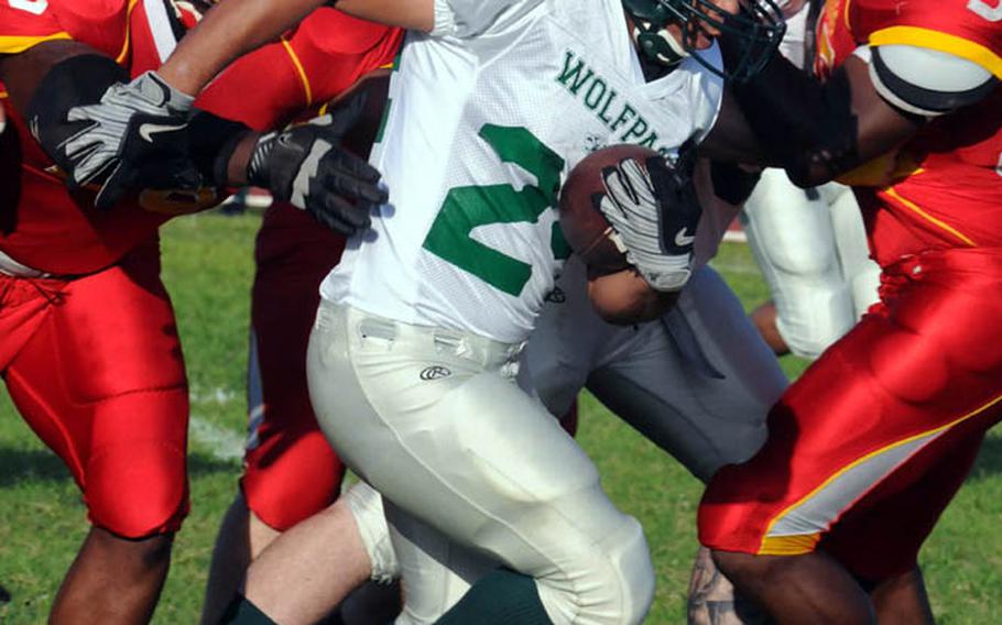 Joint Task Force Wolfpack running back Enrique Menendez tries to find running room between Foster Bulldogs defenders Dale Malone and Anthony "Radio" Linzy, right, during Saturday's U.S. Forces Japan-American Football League South Division season finale at Camp Foster, Okinawa. Foster won 30-8 to complete a 4-0 regular season.