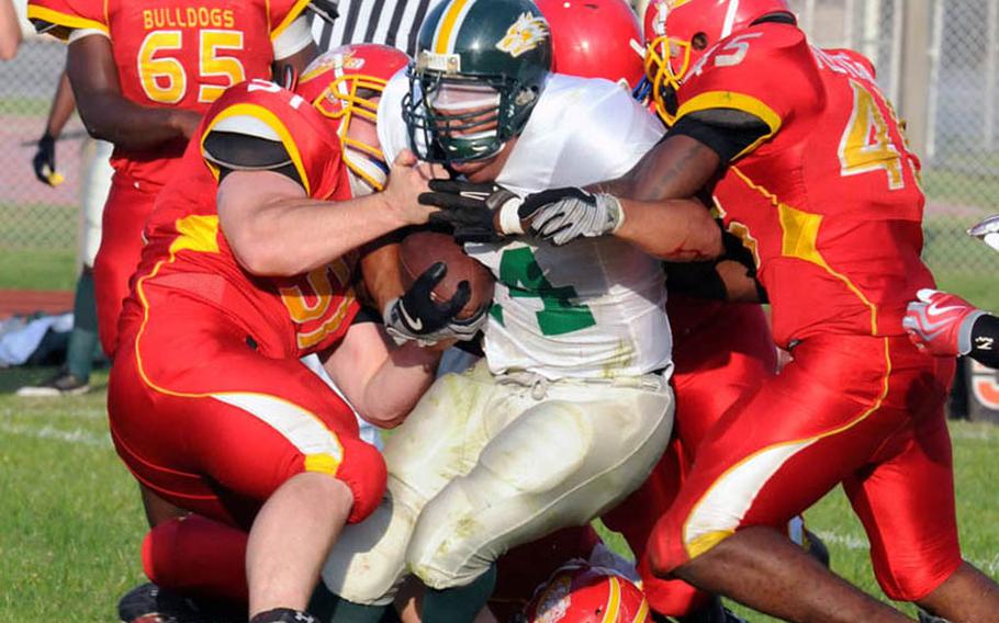 Joint Task Force Wolfpack running back Enrique Menendez gets gang-tackled by Foster Bulldogs defenders Will Good, left, Rohan Paul, below, Michael Fletcher, right and Josh Reed, rear, during Saturday's U.S. Forces Japan-American Football League South Division season finale at Camp Foster, Okinawa. Foster won 30-8 to complete a 4-0 regular season.